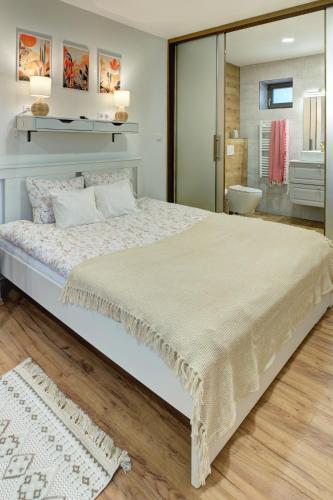 a bedroom with a large bed and a bathroom at Rozmaring Vendégház in Zalaegerszeg