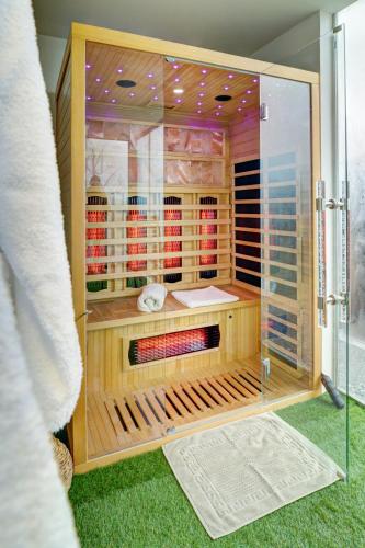 a glass cabinet with wine bottles inside of it at Rozmaring Vendégház in Zalaegerszeg