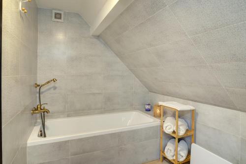 a bathroom with a bath tub and a sink at Rozmaring Vendégház in Zalaegerszeg