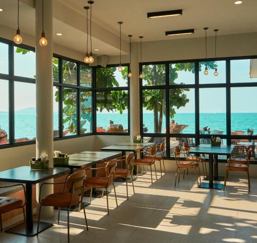 a restaurant with tables and chairs and a view of the ocean at Escape Beach Resort - New Look & Improved in Mae Nam