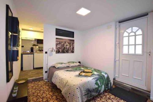 une chambre avec un grand lit et une cuisine dans l'établissement Studio dans maison individuelle, à Montpellier