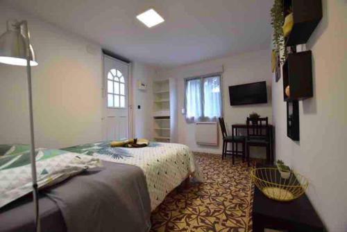 une chambre avec un lit, un bureau et une fenêtre dans l'établissement Studio dans maison individuelle, à Montpellier