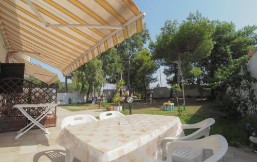 a patio with a table and white chairs at Imperatrice Rent Room - Porto Cesareo in Torre Squillace