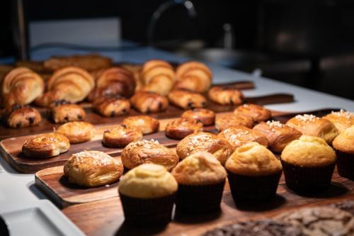 a bunch of donuts and muffins on a table at Catalonia Barcelona Beach in Barcelona