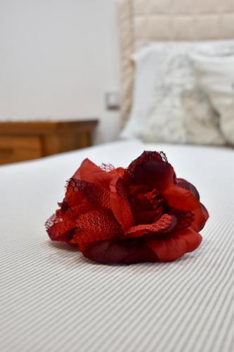 a red rose sitting on top of a bed at Cheryl Guest House in Ranco