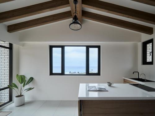 una cucina con una grande finestra e un bancone bianco di 眺浪島民宿 a Fan-shu-liao