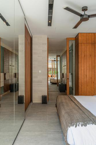 a bedroom with a bed and a glass wall at Body Factory Lifestyle Residence in Canggu
