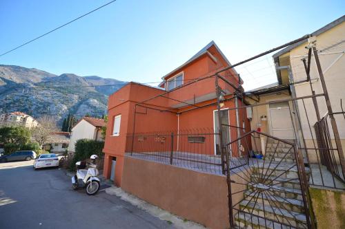 a red building with a scooter parked in front of it at the Right Choice Apartment in Kotor