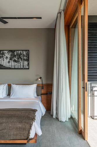 a bedroom with a bed and a large window at Body Factory Lifestyle Residence in Canggu