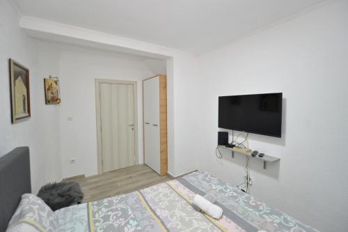 a bedroom with a bed and a flat screen tv at the Right Choice Apartment in Kotor