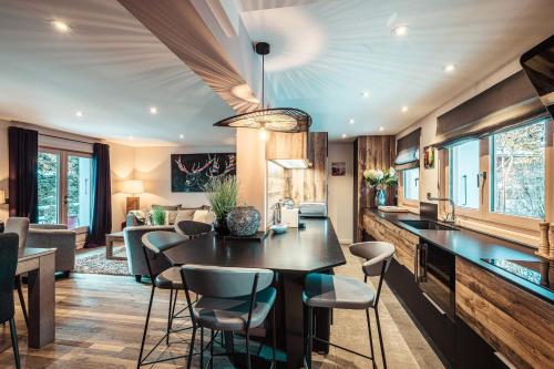 une cuisine et un salon avec une table et des chaises dans l'établissement Appartement au coeur du village de Megève, à Megève
