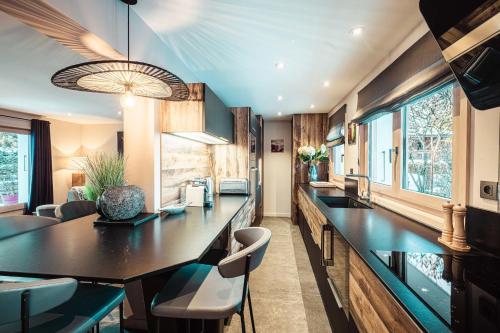 une cuisine avec un grand comptoir noir et des chaises dans l'établissement Appartement au coeur du village de Megève, à Megève