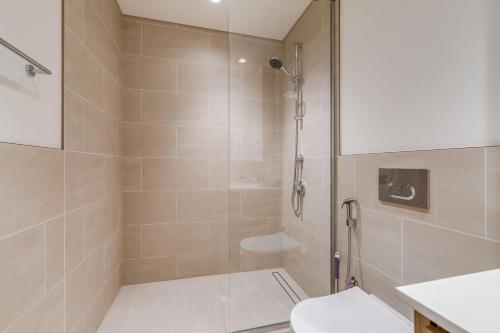 a bathroom with a shower and a toilet at Knokey Dubai Creek Beach with Lagoon Pool access in Dubai