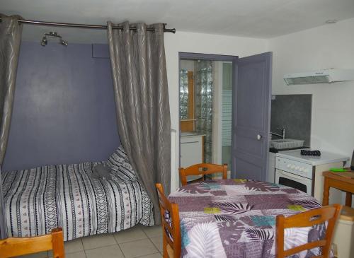 une petite chambre avec un lit et une cuisine dans l'établissement la maison jaune proche mer et marché avec wifi, à Pornichet