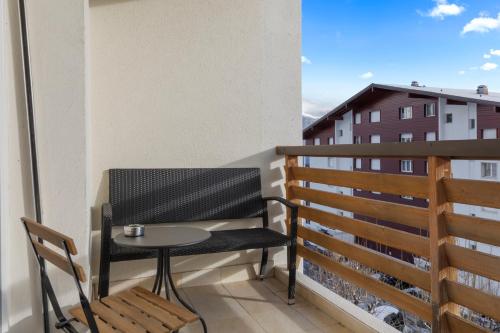 a small balcony with a table and a chair at Appartement fraîchement rénové à Crans-Montana, vue imprenable in Crans-Montana