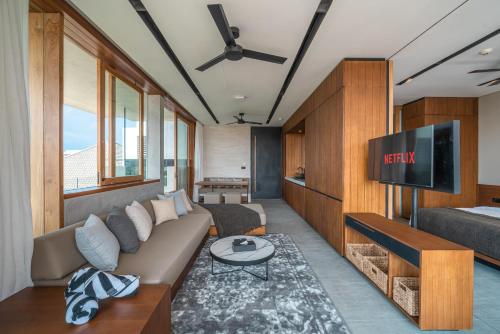 a living room with a couch and a flat screen tv at Body Factory Lifestyle Residence in Canggu