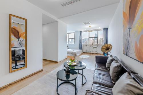 a living room with a couch and a table at Qingdao Shanhaiji Sea View B&B Wusi Square Branch in Fushansuo