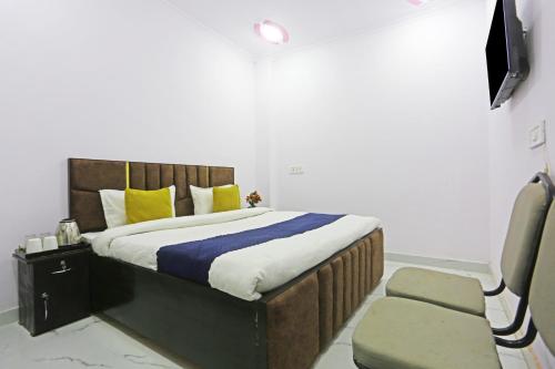 a bedroom with a large bed and a chair at Twamev Residency in New Delhi