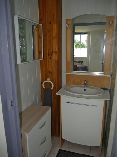 une salle de bain avec un lavabo et un miroir dans l'établissement la maison jaune proche mer et marché avec wifi, à Pornichet