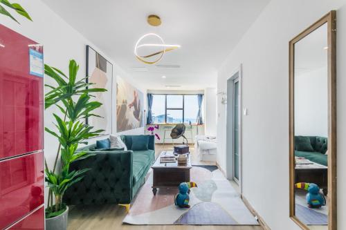 a living room with a blue couch and a mirror at Qingdao Shanhaiji Sea View B&B Wusi Square Branch in Fushansuo