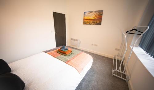 a bedroom with a white bed with a tray on it at Amazing Apartment in Warrington in Warrington