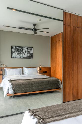 a bedroom with a bed with a glass wall at Body Factory Lifestyle Residence in Canggu