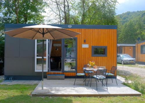 a patio with a table and an umbrella at Tinyhaus Sankt Rupert Nummer 11 in Riedenburg