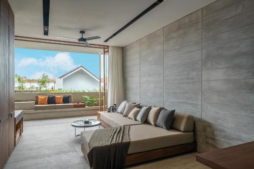 a living room with a couch and a large window at Body Factory Lifestyle Residence in Canggu