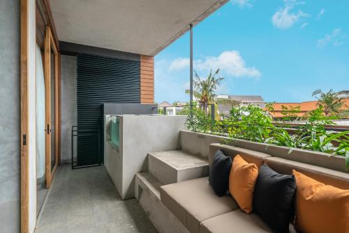 a balcony of a house with a couch at Body Factory Lifestyle Residence in Canggu