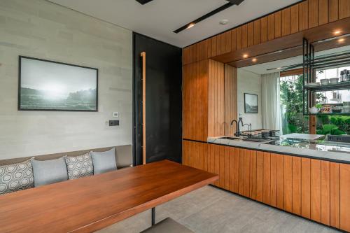 a kitchen with a wooden counter and a wooden table at Body Factory Lifestyle Residence in Canggu