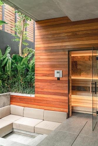 a wooden wall with a bench in front of a building at Body Factory Lifestyle Residence in Canggu