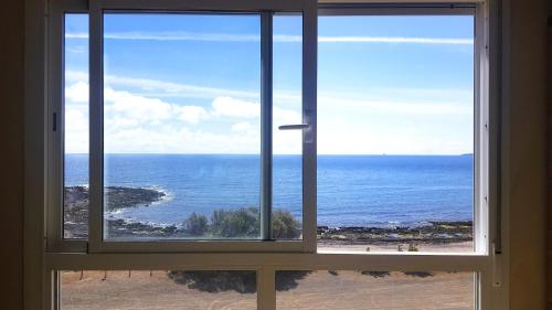 una ventana abierta con vistas al océano en Appartamento Sinestesia Oceanica, en Puerto del Rosario