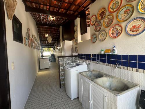 a kitchen with a sink and a washing machine at Casa Privê Maragogi Pé na areia in Maragogi