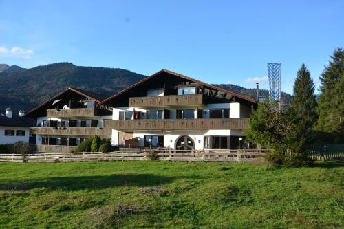 a large building with a grass field in front of it at Ferienwohnung Farchanter Alm mit Schlafzimmer, Wohnzimmer und Schlafnische in Farchant