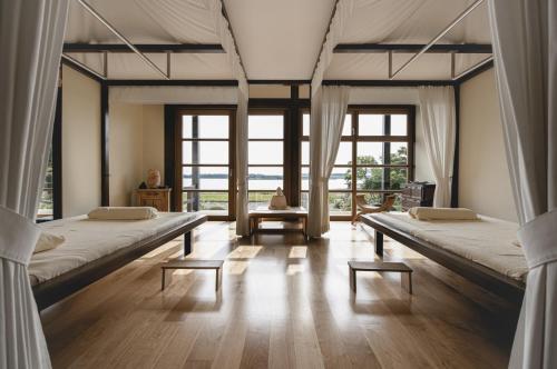 two beds in a room with large windows at Balmer See – Hotel•Golf•Spa in Balm