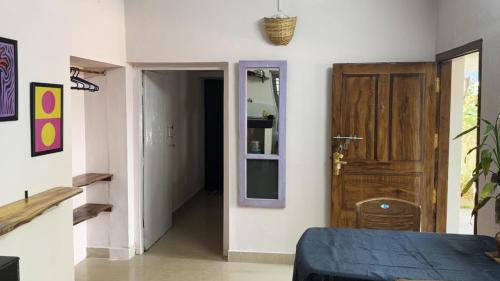 a room with a bed and a door with a mirror at BLUE SOPHY Residency in Varkala