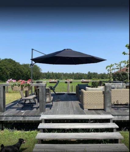 a patio with a table and an umbrella at B&B 't Mjeels Pierke in Meerle
