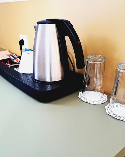 a tea kettle and two glasses on a counter at Villa Grudziądz in Grudziądz
