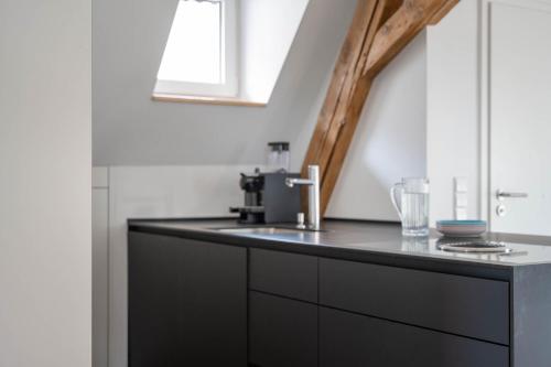 a kitchen with a black counter and a sink at Hotel Garni Villa Rosengarten in Überlingen