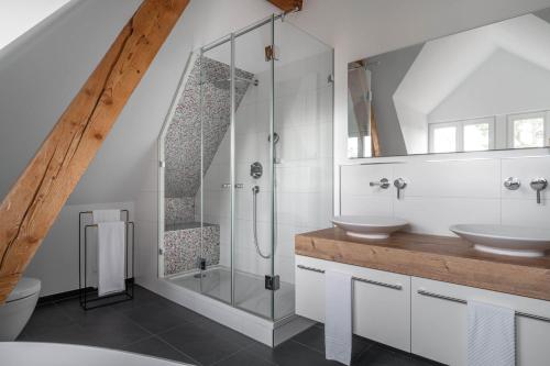 a bathroom with two sinks and a glass shower at Hotel Garni Villa Rosengarten in Überlingen