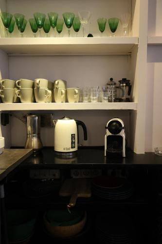 a kitchen counter with green glasses on a shelf at El Cedre Blau Vivienda con piscina en Granollers in Granollers