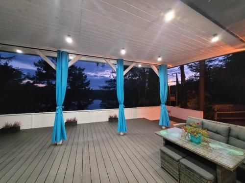 a deck with blue drapes and a couch at Tarasy Bieszkowice in Bieszkowice