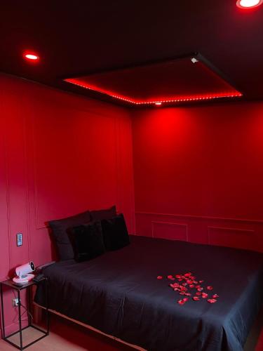 a red room with a bed with red lights on it at Le boudoir rouge - Loveroom luxueuse pour couples in La Ferté-Gaucher