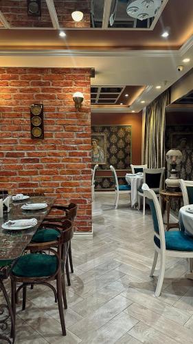 a restaurant with tables and chairs and a brick wall at Hotel Queen in Tirana