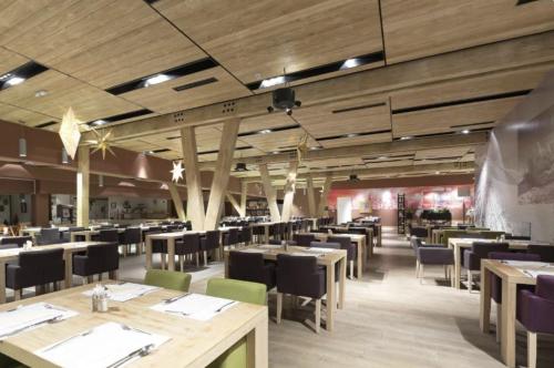 a restaurant with wooden floors and tables and chairs at Apartman C437 Aparthotel Vucko Jahorina privatni apartman in Jahorina