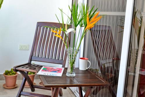 a vase of flowers sitting on a chair with a book at Acquah Place Residences in Accra