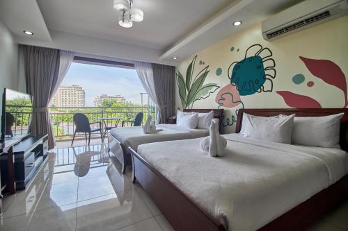 two beds in a hotel room with a crab mural on the wall at Mactan Resort by 1521 in Mactan