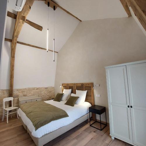 une chambre avec un grand lit et une chaise dans l'établissement Château de Belmont-Sainte-Foi, à Belmont-Sainte-Foi