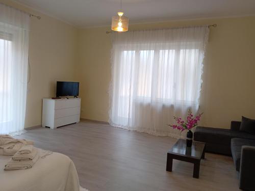 a living room with a couch and a table with flowers at Affittacamere Lusitana Alloggi 2 in Foligno