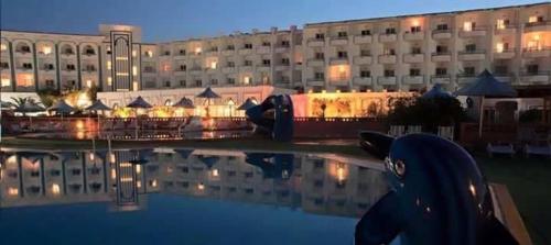 a large building with a swimming pool in front of it at Aylimas Beach & Resort Monastir in Monastir